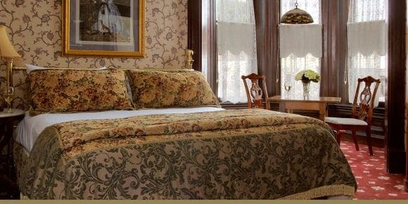 Ira Russ view of bed and table with two chairs by the window